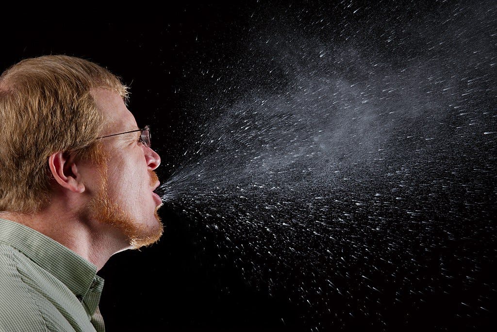 Man sneezing viral particles