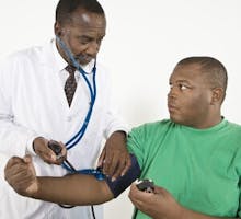 Doctor checking an African American man's blood pressure