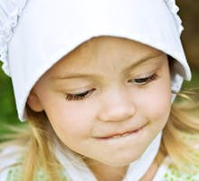 Amish kid in traditional clothing and bonnet