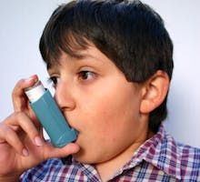 young boy with asthma using an inhaler