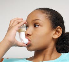 a young girl using an asthma inhaler, Primatene Mist