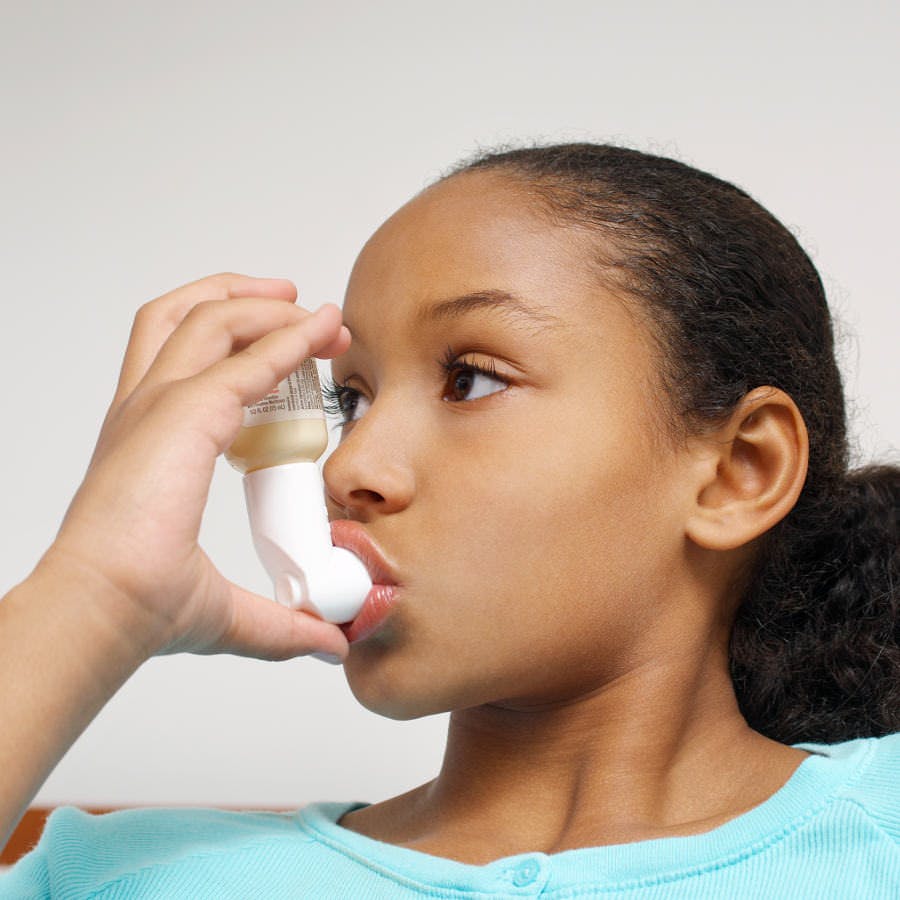 a young girl using an asthma inhaler, Primatene Mist