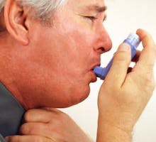 a man having an asthma attack using an inhaler