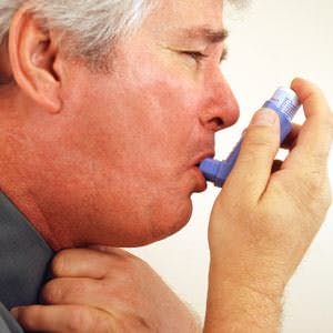 a man having an asthma attack using an inhaler