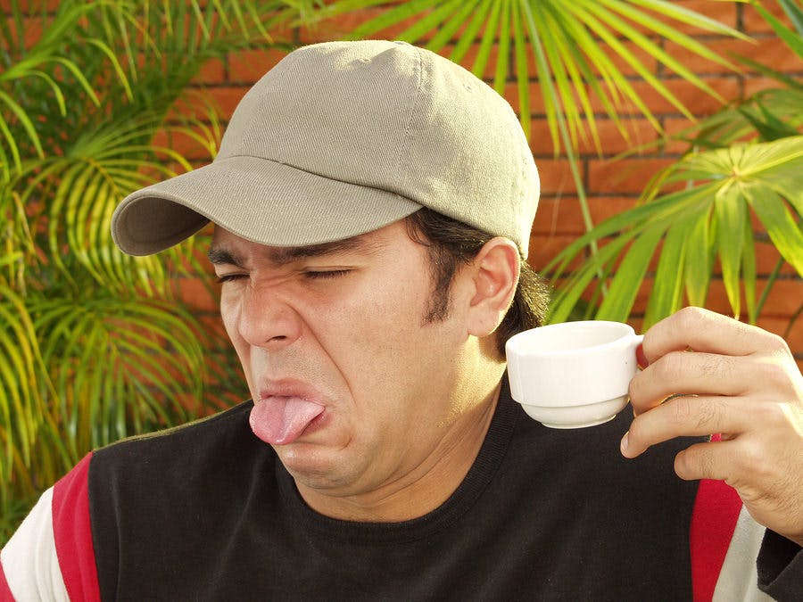 Man sticking out his tongue because of Indigestion from coffee