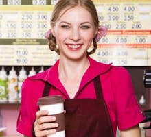 a female barista with a coffee in a carry out cup