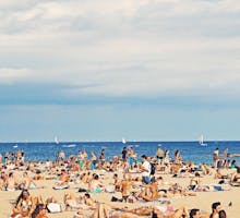 people at the beach sunbathing