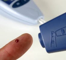 a person checking their blood sugar with a pin prick device