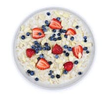 Bowl of hot oatmeal breakfast cereal with fresh berries, cooked oatmeal