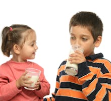 Two children drinking skim milk
