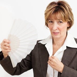 Businesswoman in Menopause fanning herself
