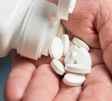 calcium dietary supplements in the palm of a woman's hand