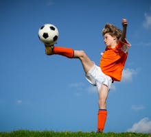 a child kicking a soccer ball
