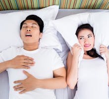 Man snoring and keeping his unhappy wife awake