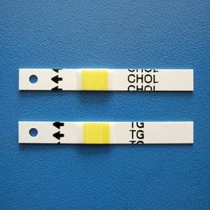Cholesterol and triglycerides strips over a blue background
