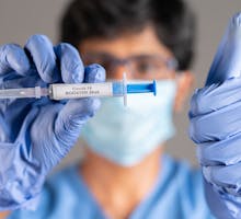 doctor holds syringe with vaccine to prevent breakthrough infections through Covid vaccination
