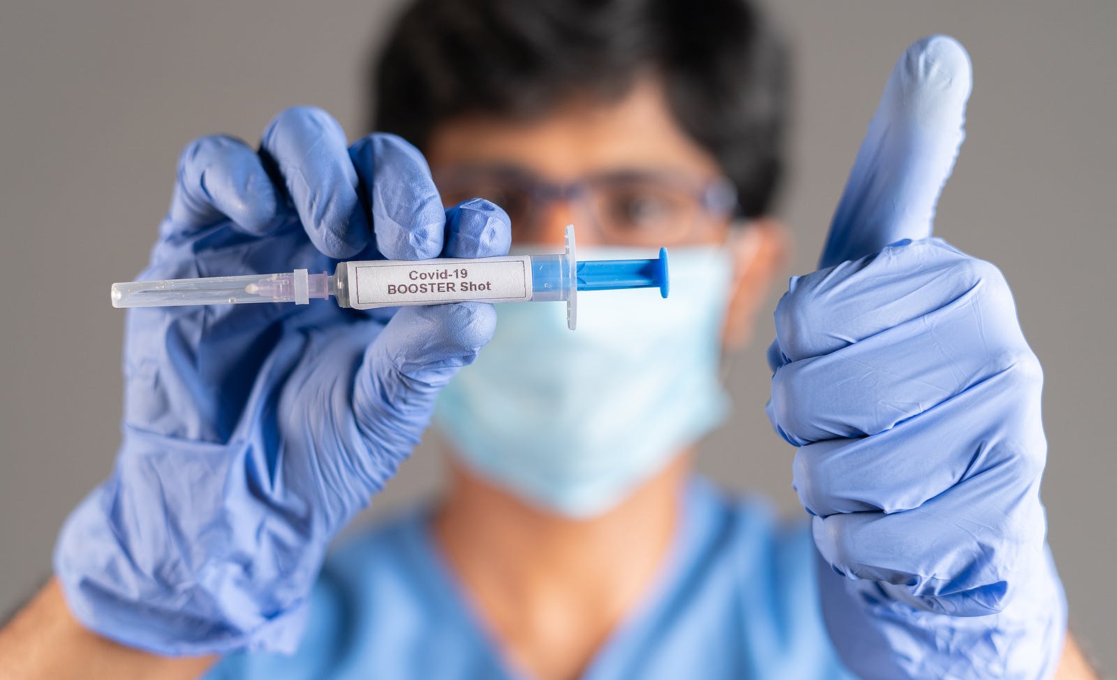 doctor holds syringe with vaccine to prevent breakthrough infections through Covid vaccination