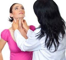 Doctor endocrinologist checking tyroide goiter of pregnant woman and holding hands on her throat