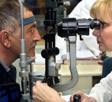 and ophthalmologist examines an older patient's eyes for macular degeneration and glaucoma