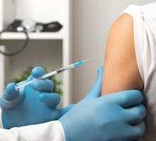 Doctor prepares to give a flu shot or COVID-19 vaccine