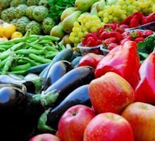 market display of apples, eggplants, peppers, grapes, green beans, colorful vegetables