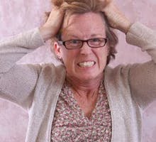 A very frustrated middle-aged woman pulling her hair out