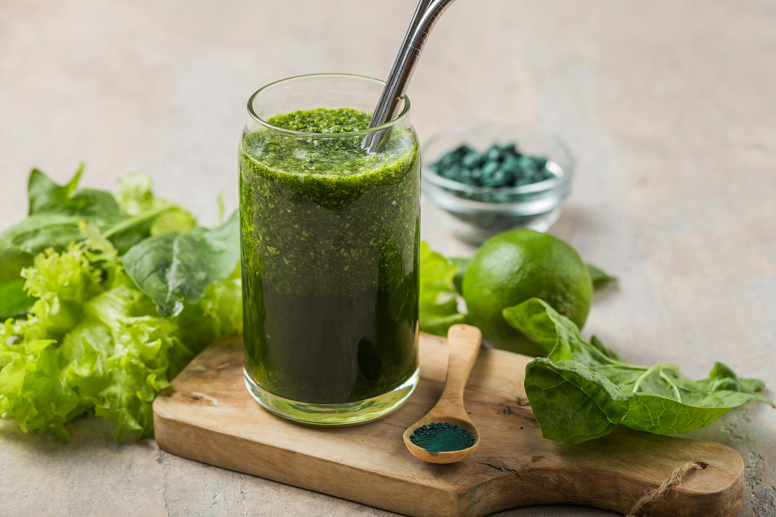 Green smoothie with spirulina. Young barley and chlorella spirulina. Detox superfood.Glass Jar of Healthy Green Smoothie Detox Drink wirh Green Apple Celery and Raw Spinach Diet Beverage Above Close Up
