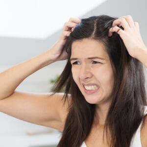 woman scratching scalp
