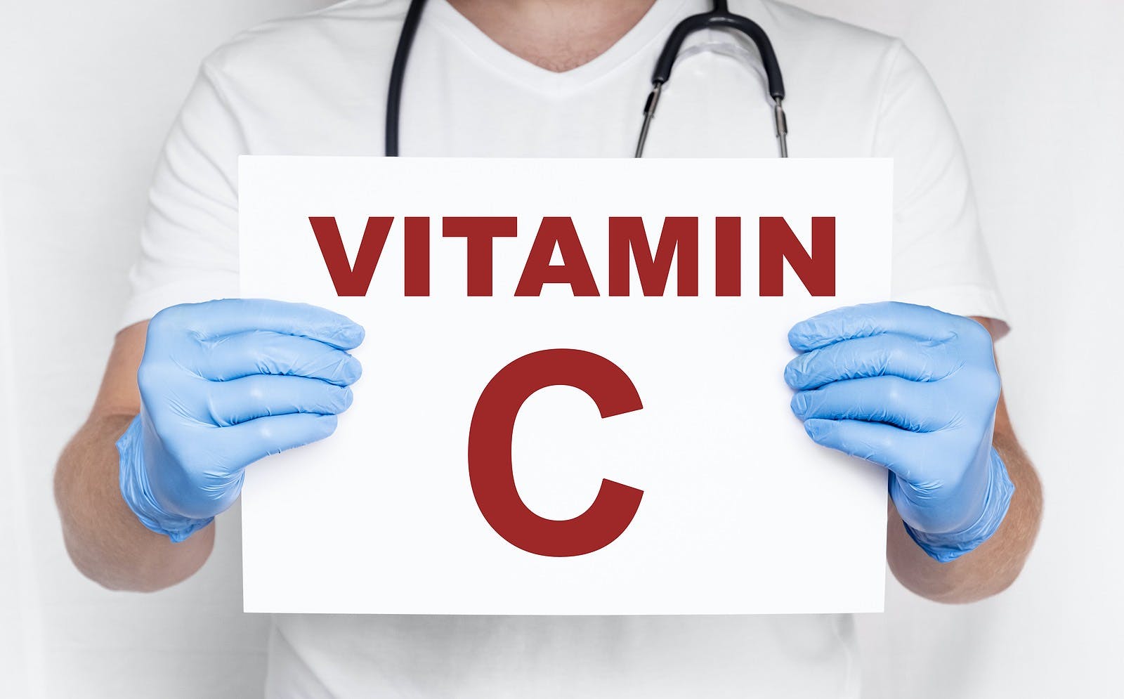 Male doctor holding a card that says vitamin C