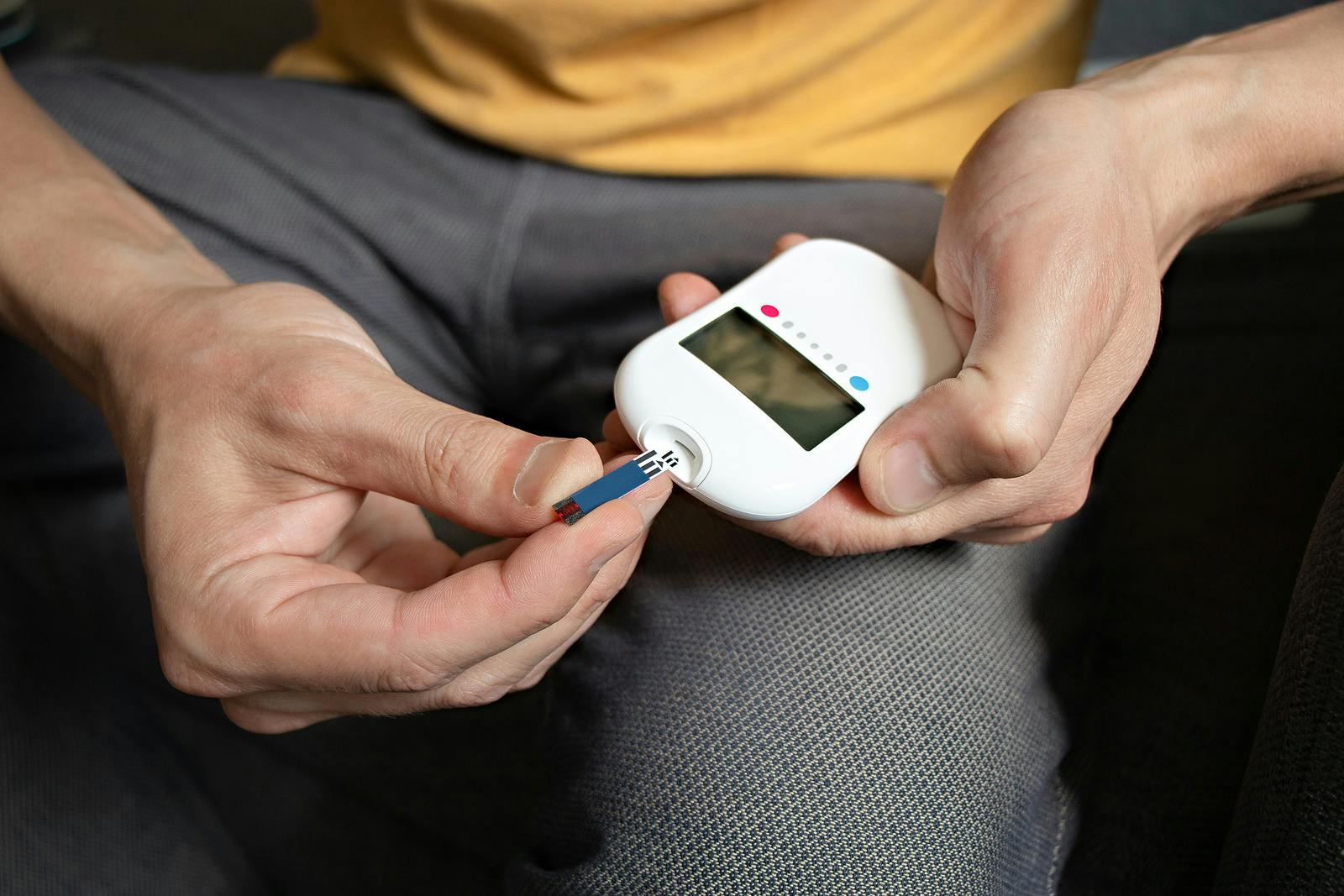 Man with type 2 diabetes checks blood sugar on glucometer to manage diabetes