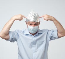 man wearing a surgical mask and an aluminum hat