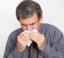 an sneezing into a handkerchief, suffering with a cold, flu
