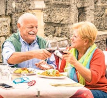 Senior couple having fun and eating mediterranean meal during travel