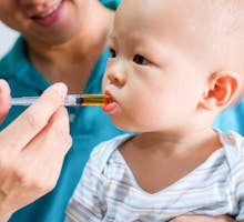 Toddler being given a measured dose of oral medication