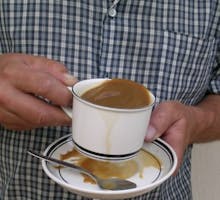 Person with Parkinson's disease spilling coffee from shaking