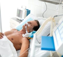 patient in hospital bed on ventilator
