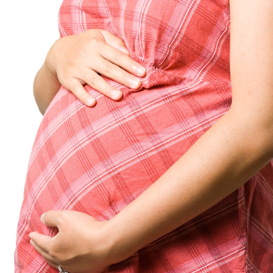 a pregnant woman holding her abdomen