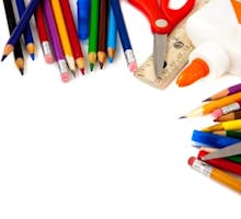 Assorted school supplies including pens pencils scissors white glue and a ruler