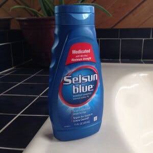 A bottle of Selsun Blue dandruff shampoo to ease eczema, under-breast rash with dandruff shampoo