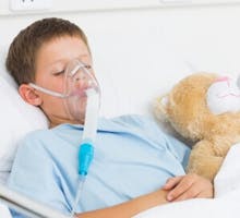 a sick boy wearing an oxygen mask