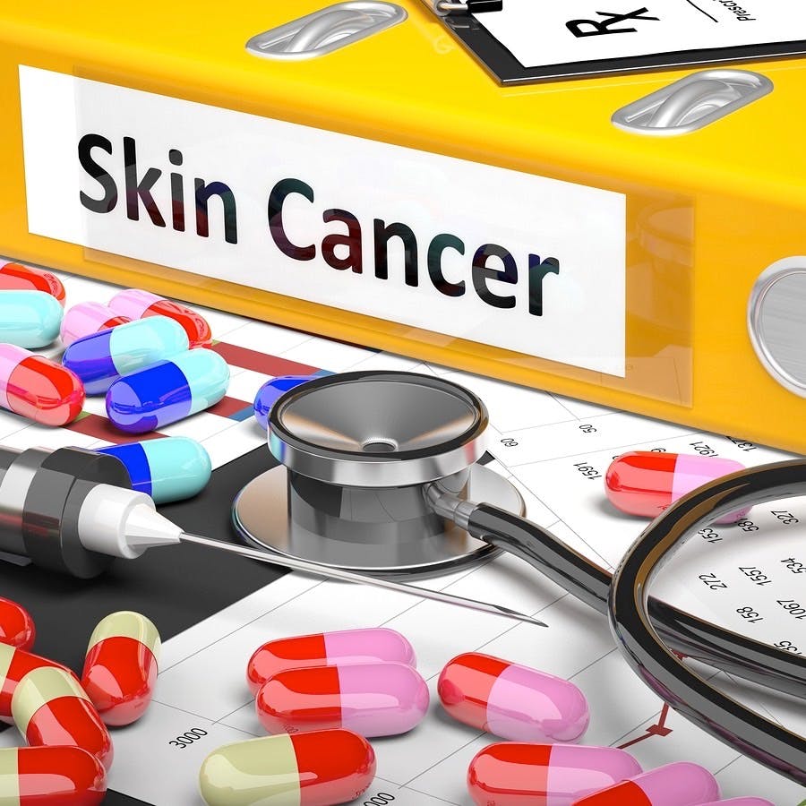 Illustration of doctor&#8217;s desktop with different pills, capsules, statoscope, syringe, yellow folder with label &#8216;Skin Cancer&#8217;
