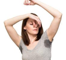 a woman with sweaty and smelly underarms holding her nose