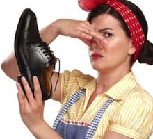 housewife holding a smelly shoes with facial expression