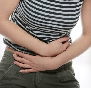 person holding their stomach in pain, calm chronic diarrhea, IBS, low FODMAP diet