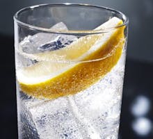 a glass of tonic water with a slice of lemon