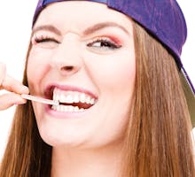 Smiling teen girl holding a stick of sugar-free gum