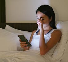 Woman feeling eye pain when using cellphone at night