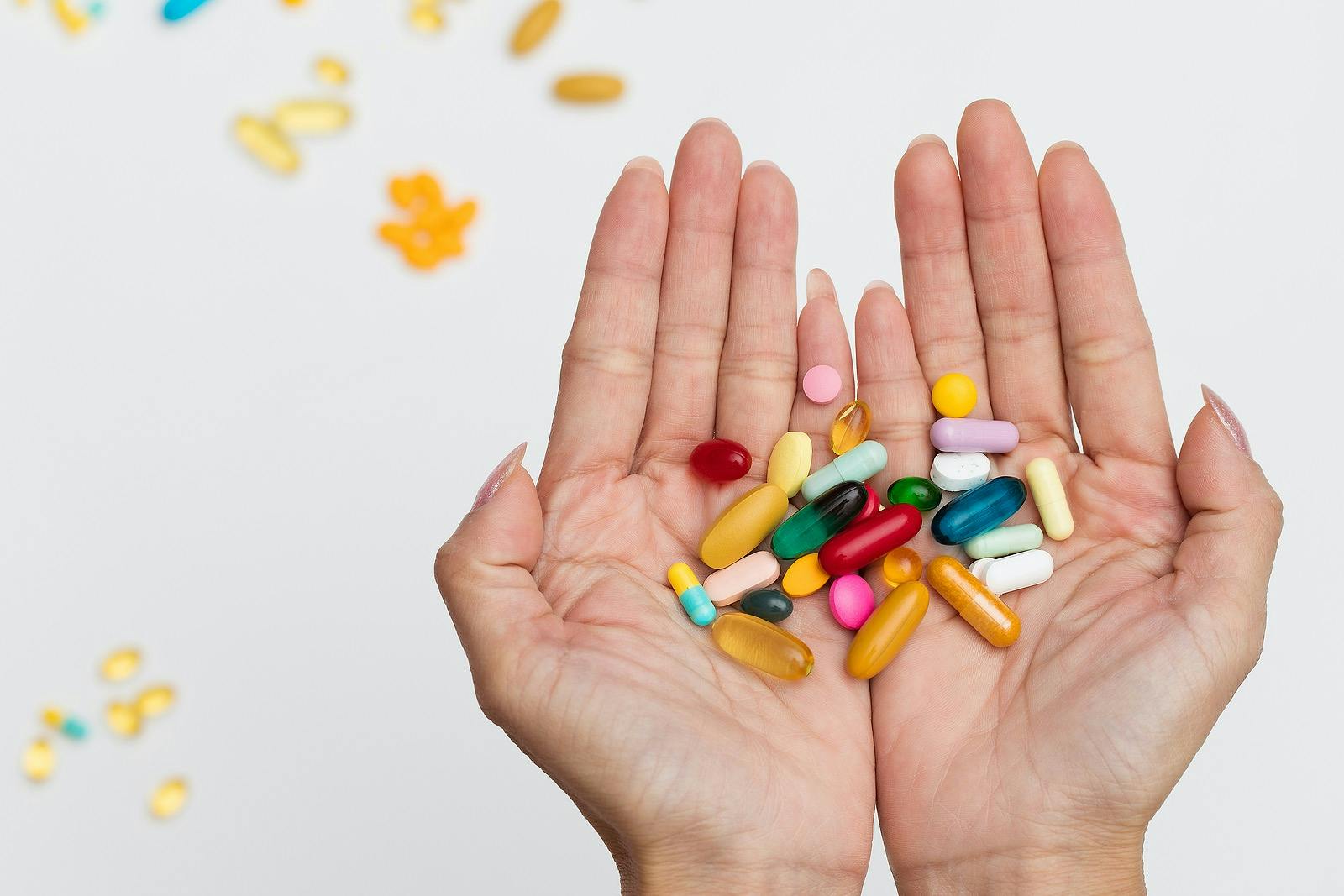 woman holding handful of pills