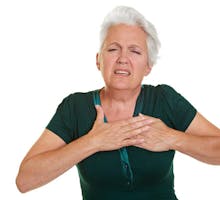 Senior woman having heart attck and holding hand to her chest