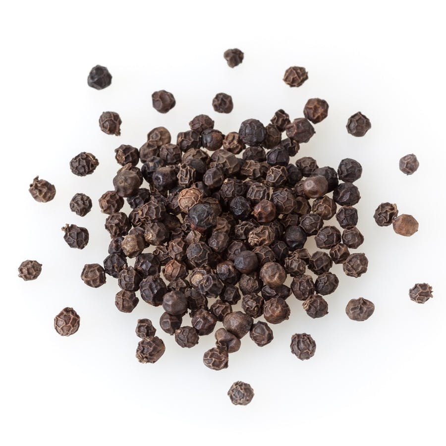 Heap of black pepper corns isolated on white background
